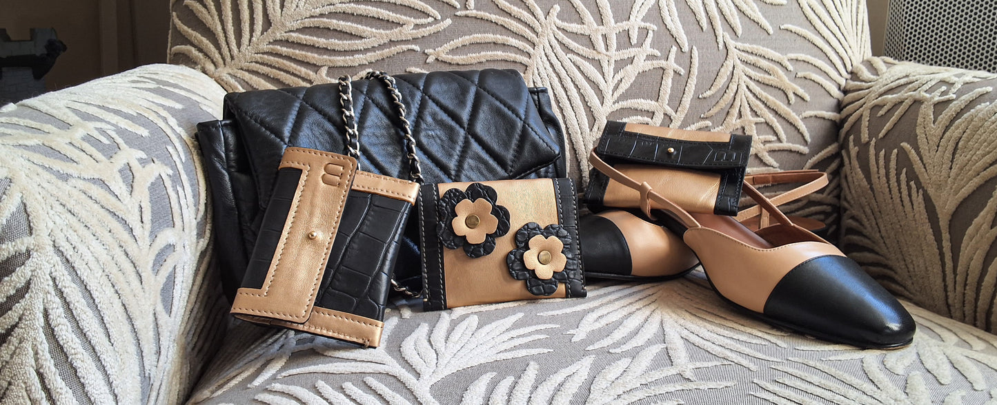 Mise en scène du porte carte pivoine sur un canape avec un sac matelassé noir et des chaussures a talon