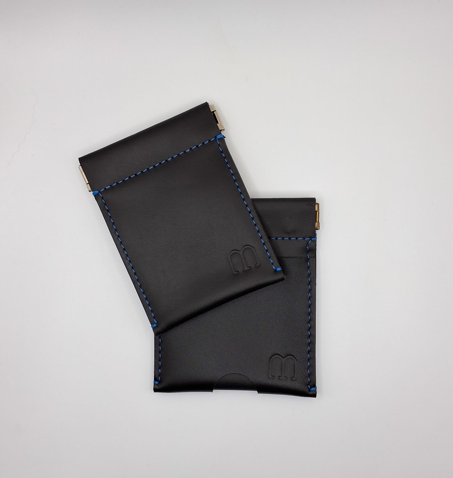 Deux porte monnaie clic clac en cuir noir et piqure bleue