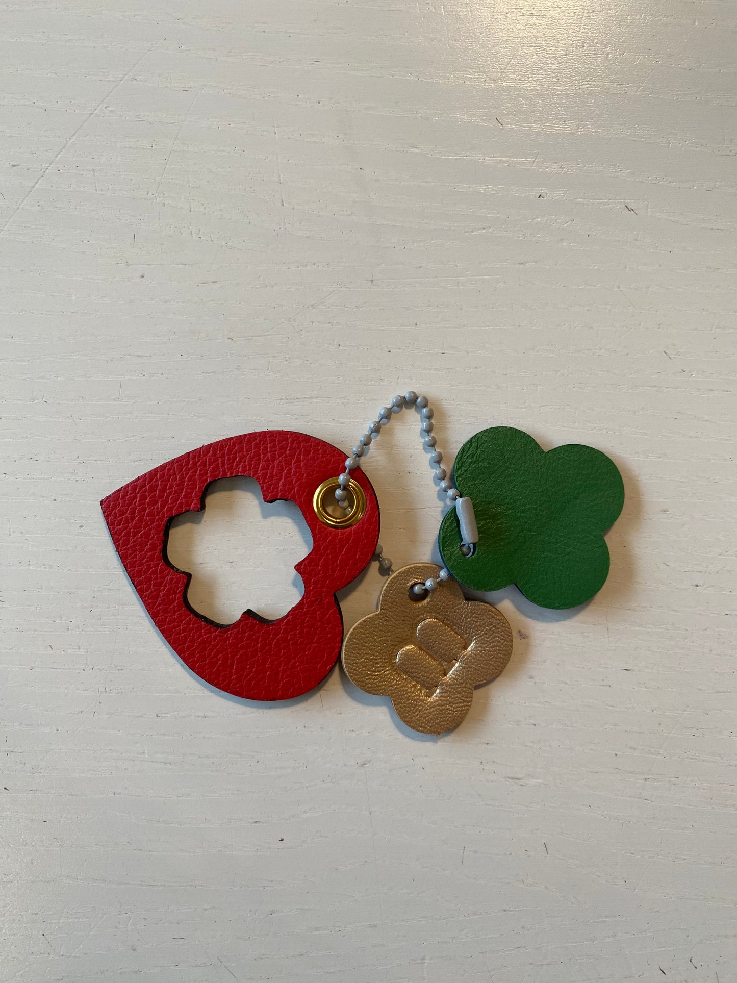 Porte clef en cuir composé de 3 éléments aux couleurs variées et en forme de cœur et de trèfle