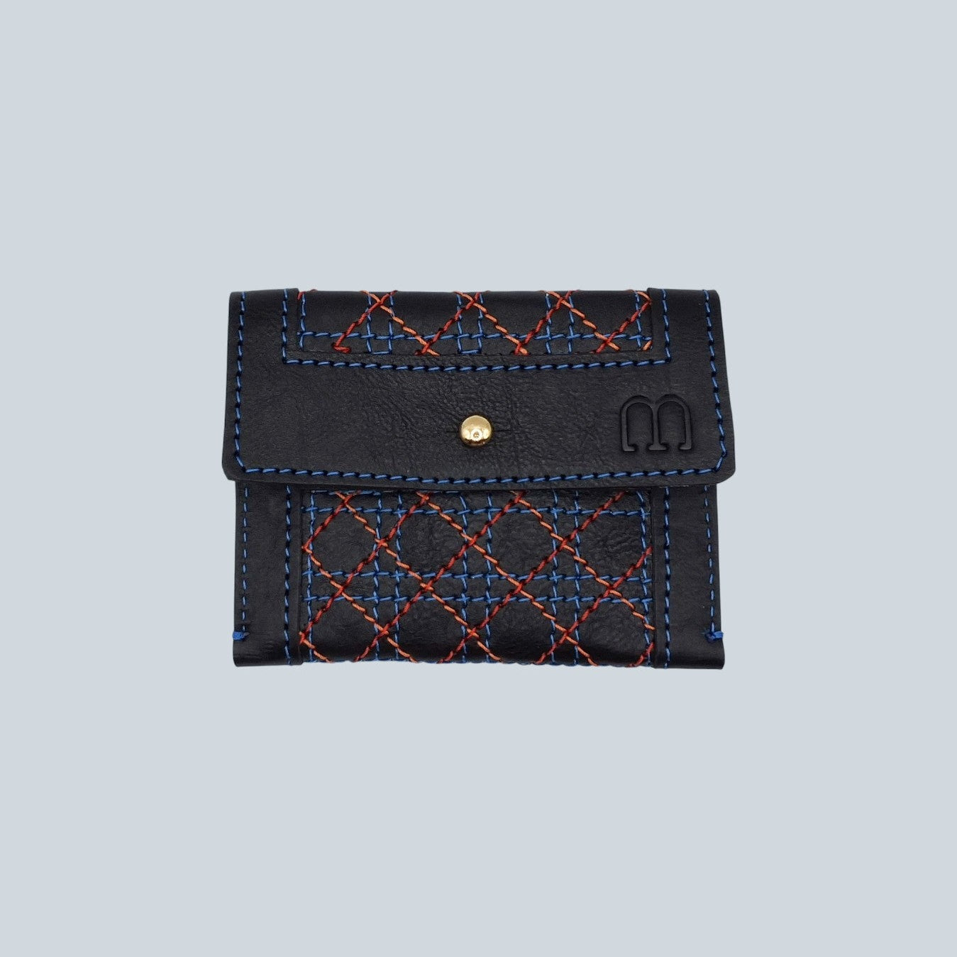 Porte cartes noir avec surpiqûres bleu, rouge et orange motif cannage et embossage M à droite vue de l'avant plié.