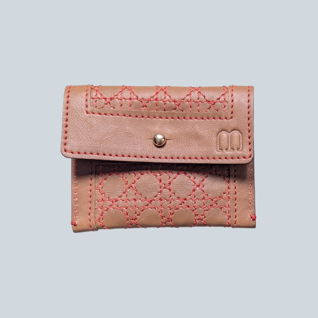 Porte cartes camel avec surpiqûres rouge motif cannage et sigle M embossé à droite.