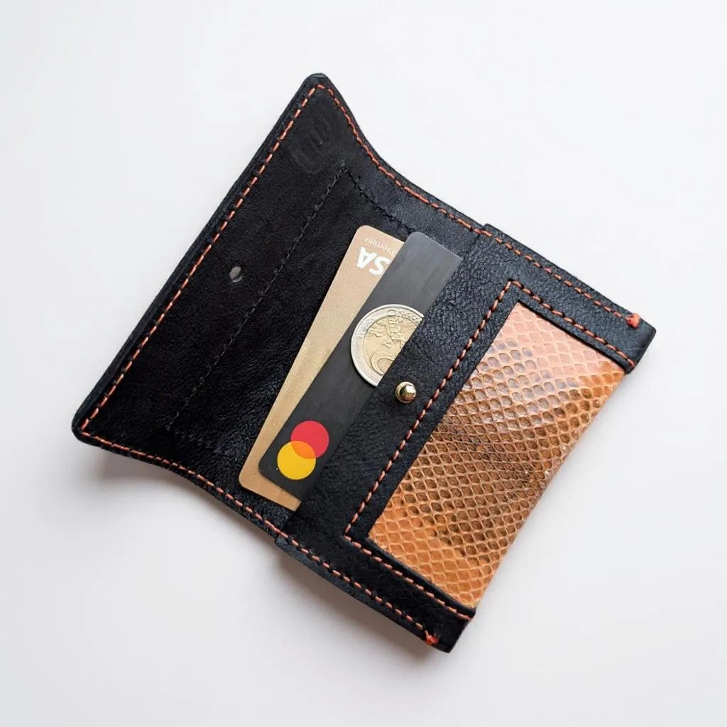 Portes cartes noir et serpent d'eau orange et surpiqûres oranges, déplié avec 2 cartes format CB et une pièce de deux euros.