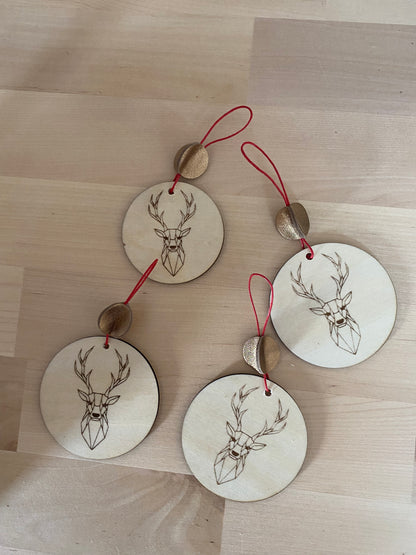 décorations de noël en bois posées sur un rondin de bois.