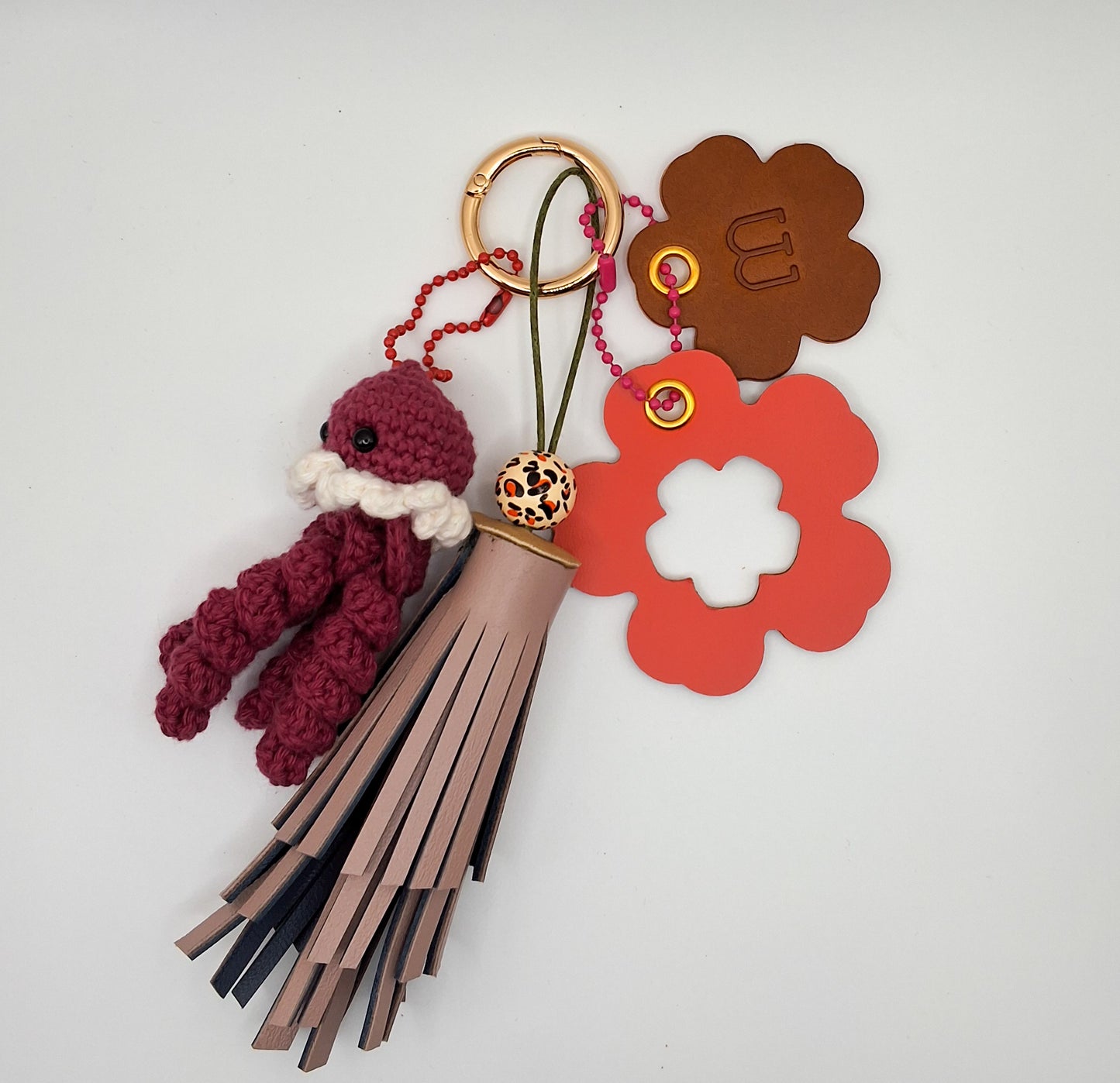 Bijoux de sac en cuir sur fond blanc avec petite pieuvre en crochet bordeau