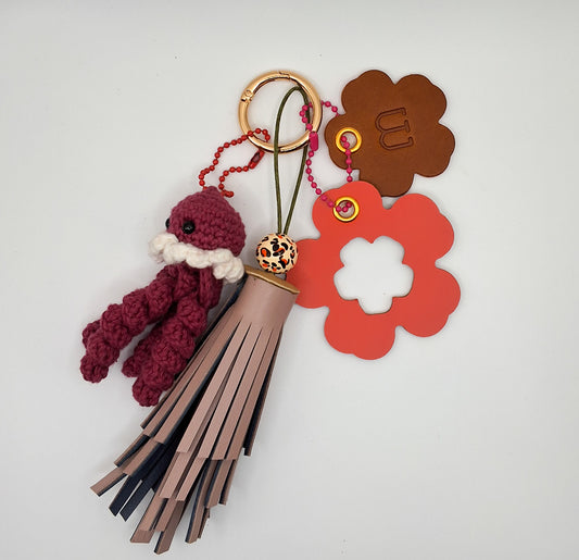 Bijoux de sac en cuir sur fond blanc avec petite pieuvre en crochet bordeau