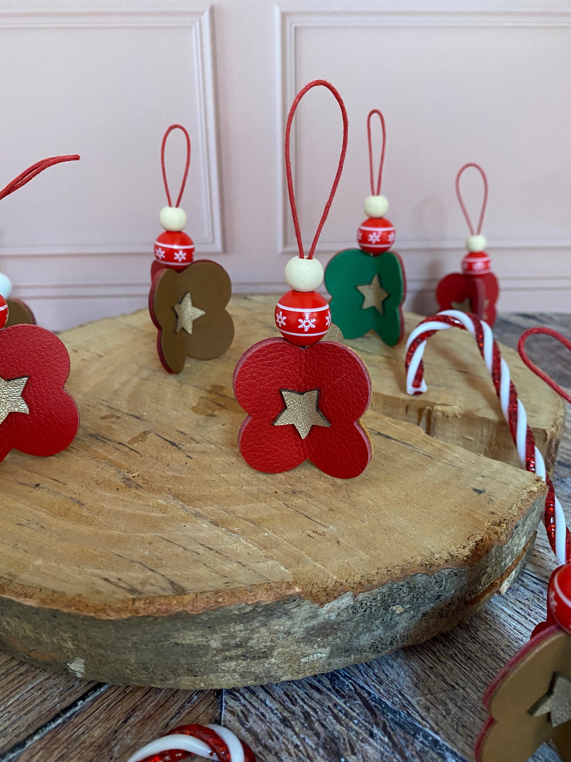 décorations de noël en cuir posées sur un rondin de bois.