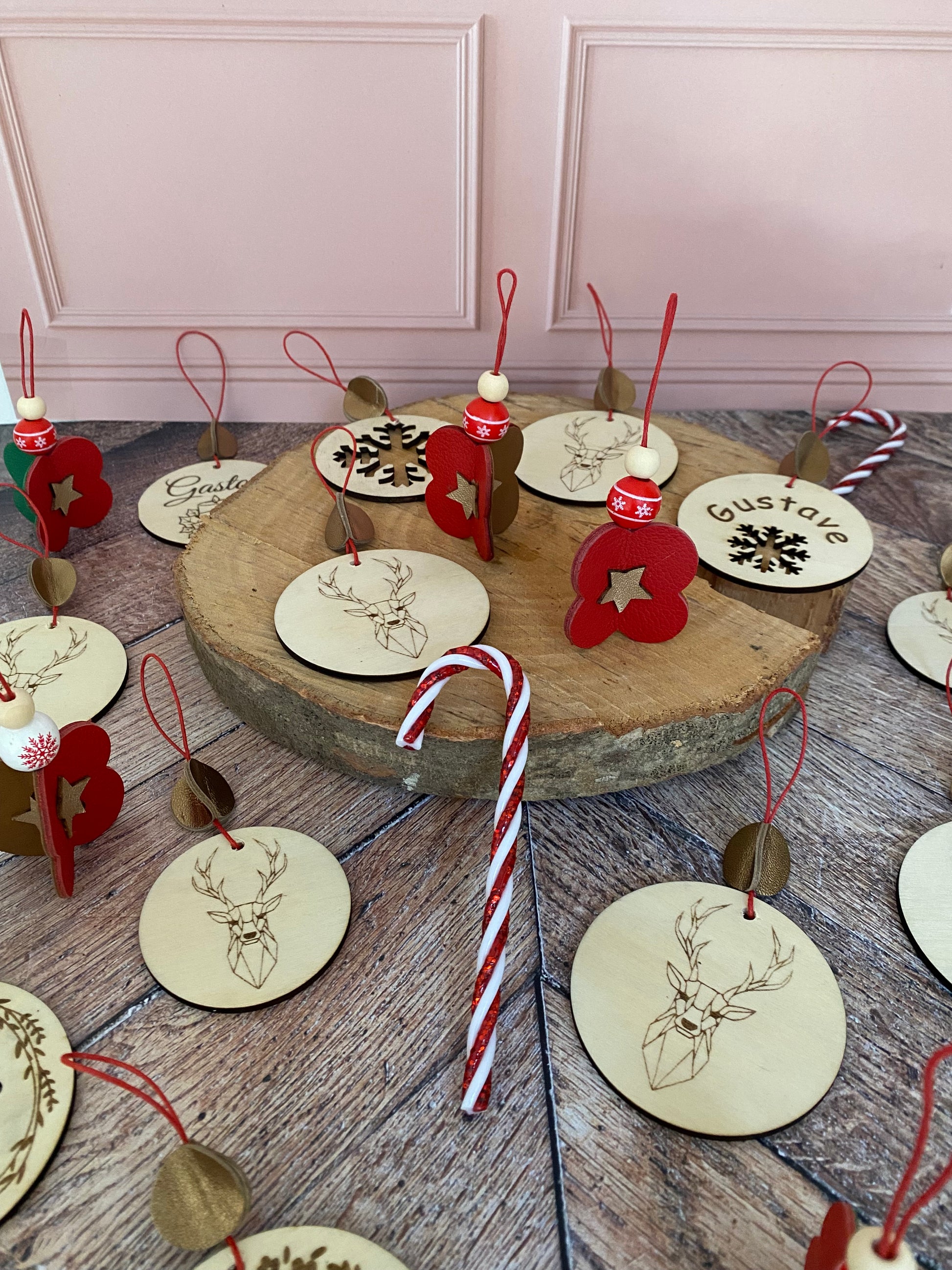 décorations de noël en cuir posées sur un rondin de bois.