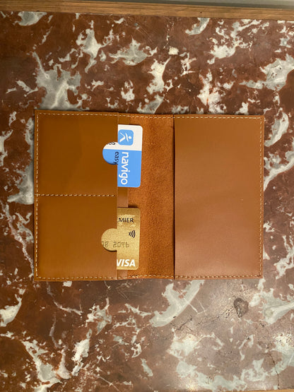 protège passeport ouvert avec des cartes dedans posé sur un plateau en marbre