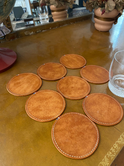 sous-verres en cuir disposés sur un bureau ancien avec un verre à whisky dessus
