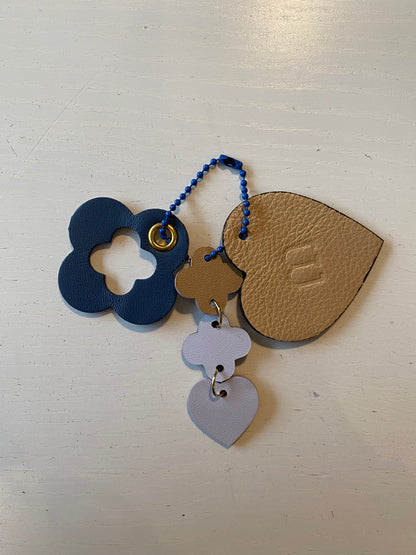 Porte clef en cuir composé de 3 éléments en forme de cœur et de trèfle sur donc blanc 