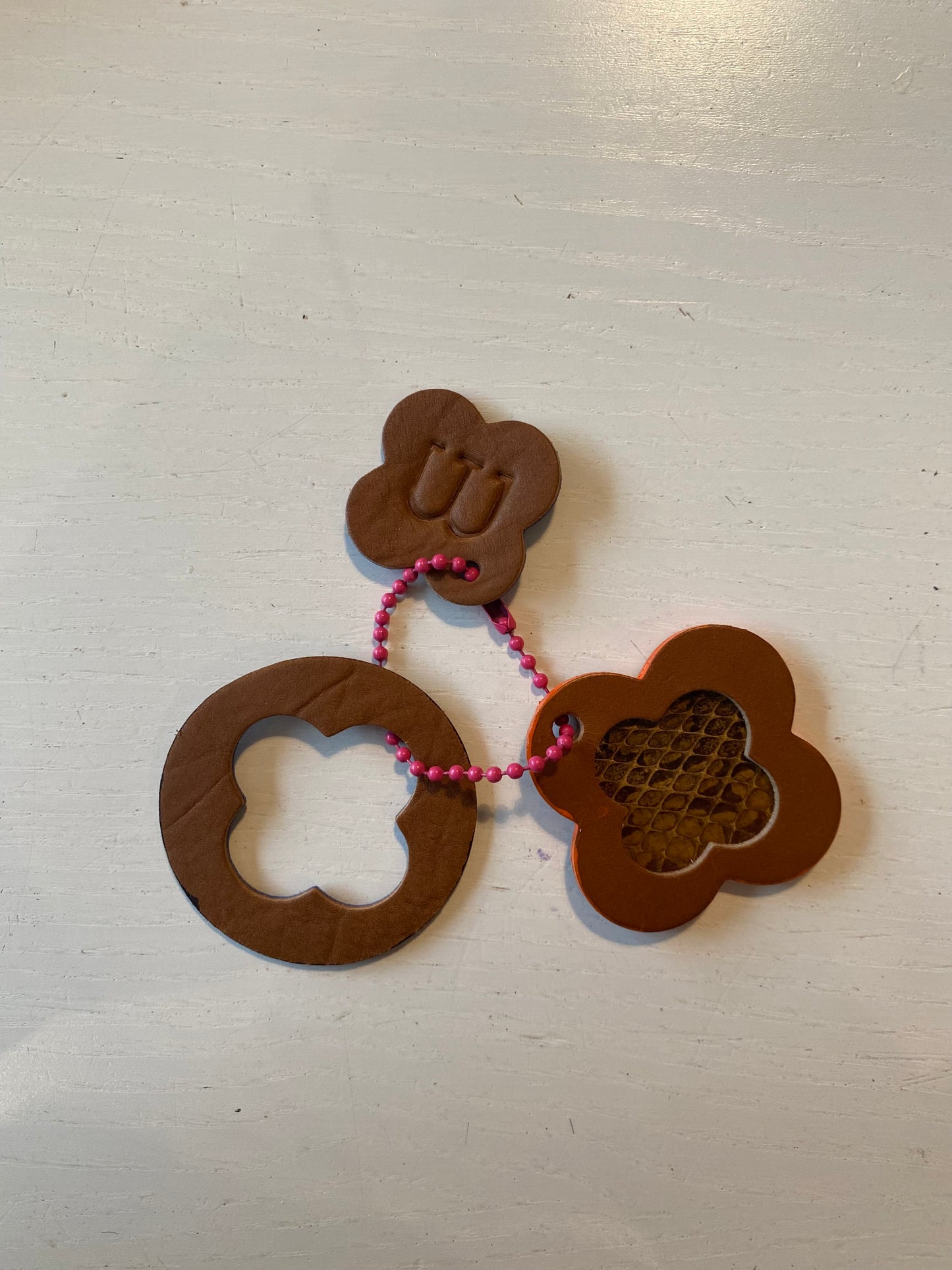 Porte clef en cuir composé de 3 éléments à dominante marron de forme ronde ou de trèfle 