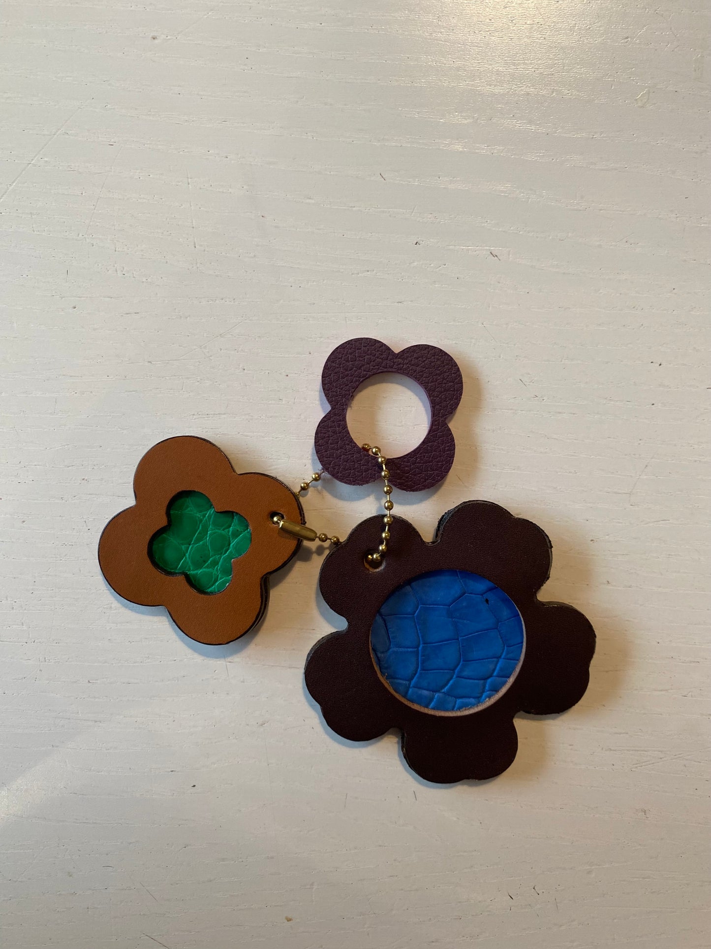 Porte clef en cuir composé de 3 éléments en forme de trèfle et de fleur 