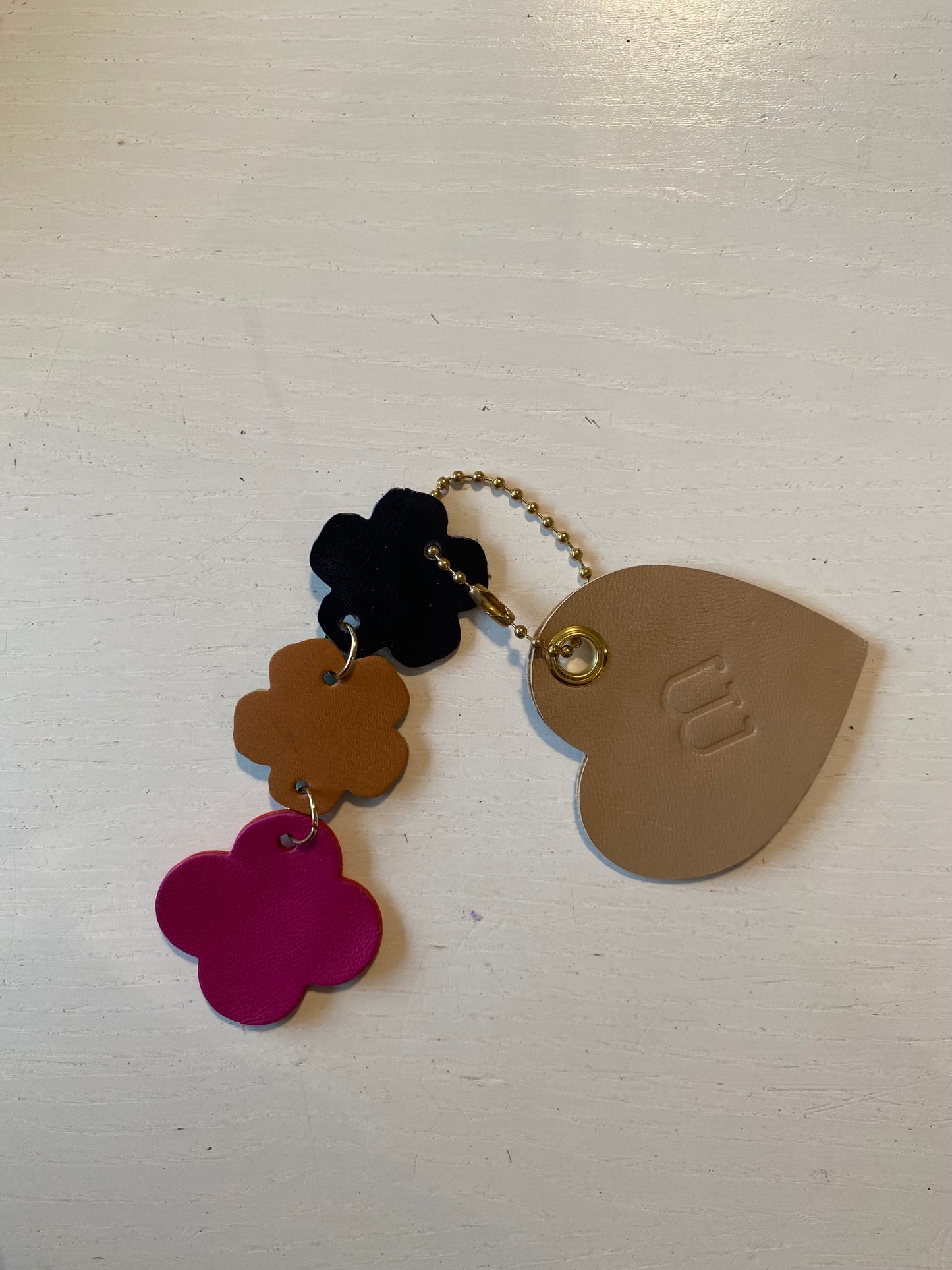 Porte clef en cuir composé de 2 éléments en forme de cœur et une suite de fleur 