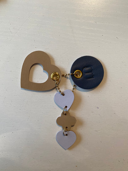 Porte clef en cuir compose de 3 éléments en forme en cœur de rond et de trèfles sur fond blanc 