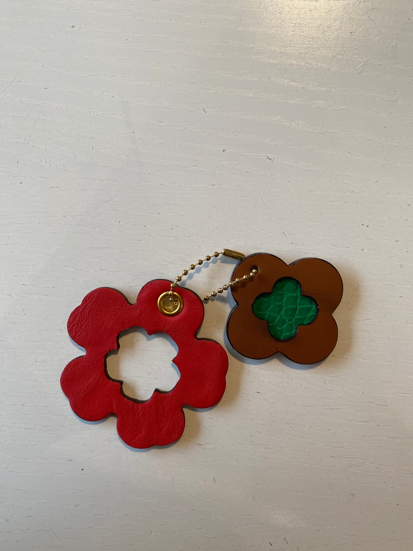 Porte clef en cuir composé de deux éléments en forme de trèfle et de fleur 