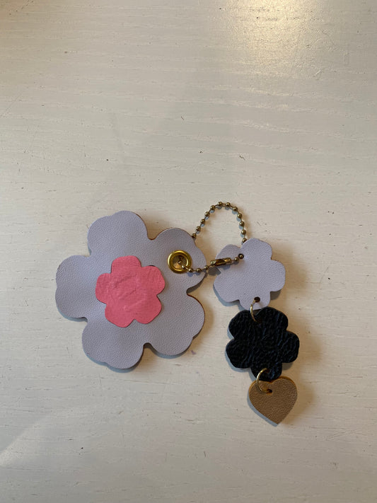 Porte clef en cuir composé de deux éléments en forme de fleur.