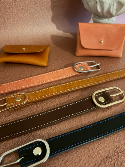 4 ceintures en cuir au tannage naturel sont posées sur un fond terracotta