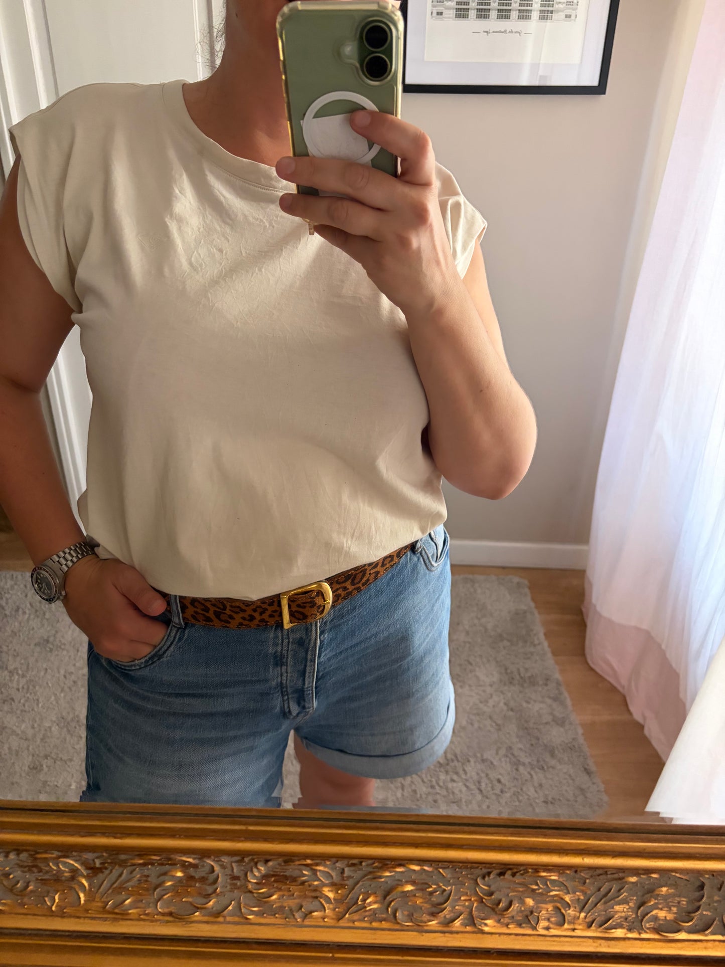 la ceinture en cuir fantaisie léopard est présentée portée par un modèle avec un short en jean et un haut blanc. 