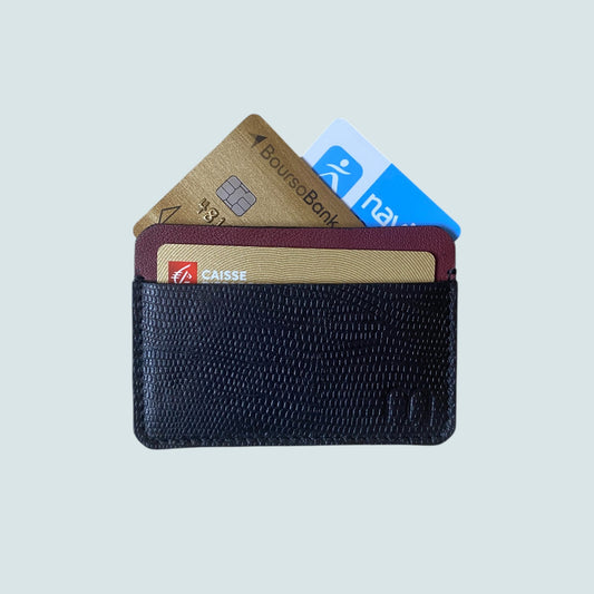 Porte carte compact en cuir noir et bordeau a deux compartiments. On voit 3 cartes banquaires qui depassent 