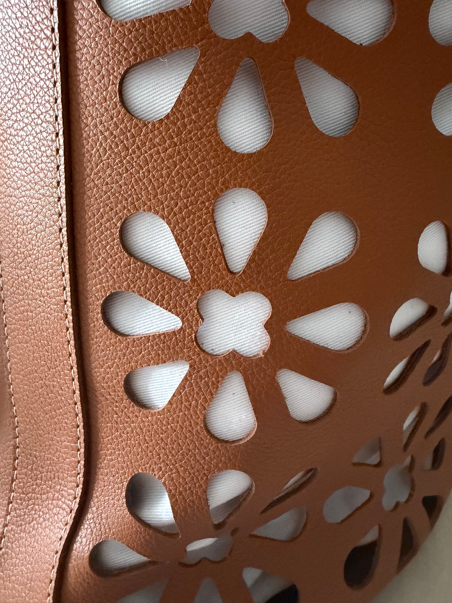 vue en gros plan des perforations d'inspiration broderie anglaise sur le sac. 