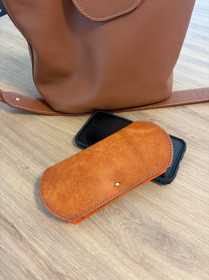 étui à lunettes plat fermé réalisé en cuir marron clair tannage végétal mis en situation sur une table