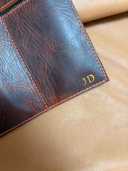 personnalisation d'une pièce en cuir par l'apposition des initiales du client en doré dans le coin en bas de la pièce.