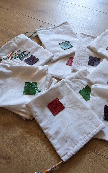 Plusieurs pochettes de rangement de différentes couleurs disposées les uns sur les autres.
