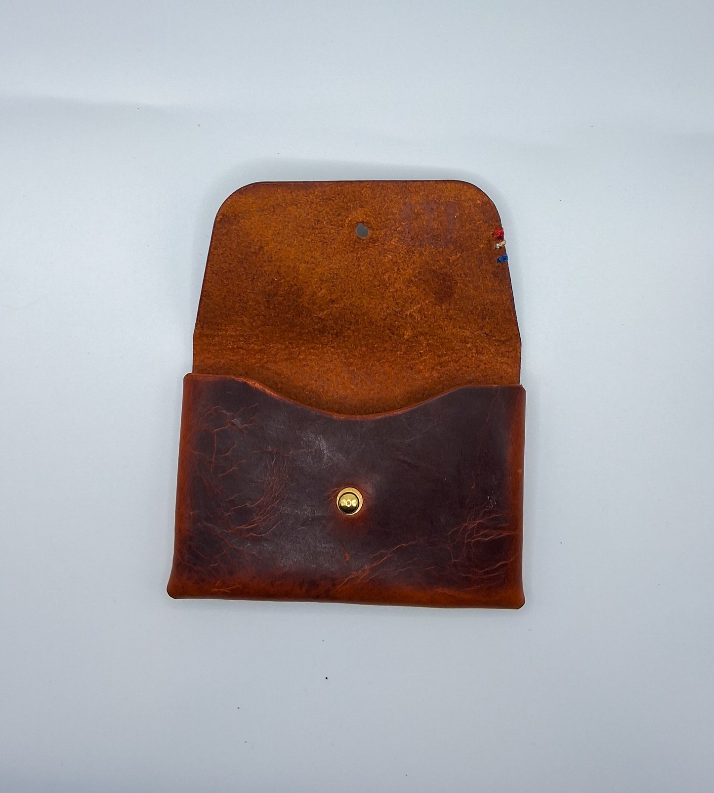 le porte carte est en cuir wax marron. il est posé sur un fond blanc