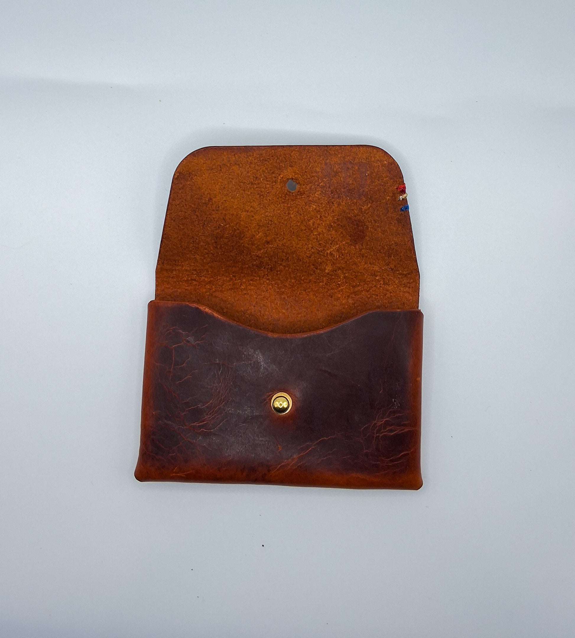 le porte carte est en cuir wax marron. il est posé sur un fond blanc