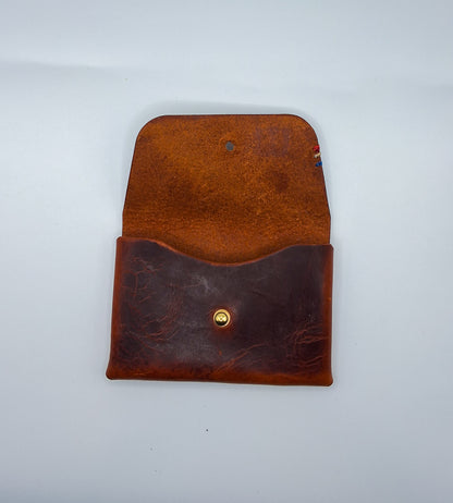 le porte carte est en cuir wax marron. il est posé sur un fond blanc