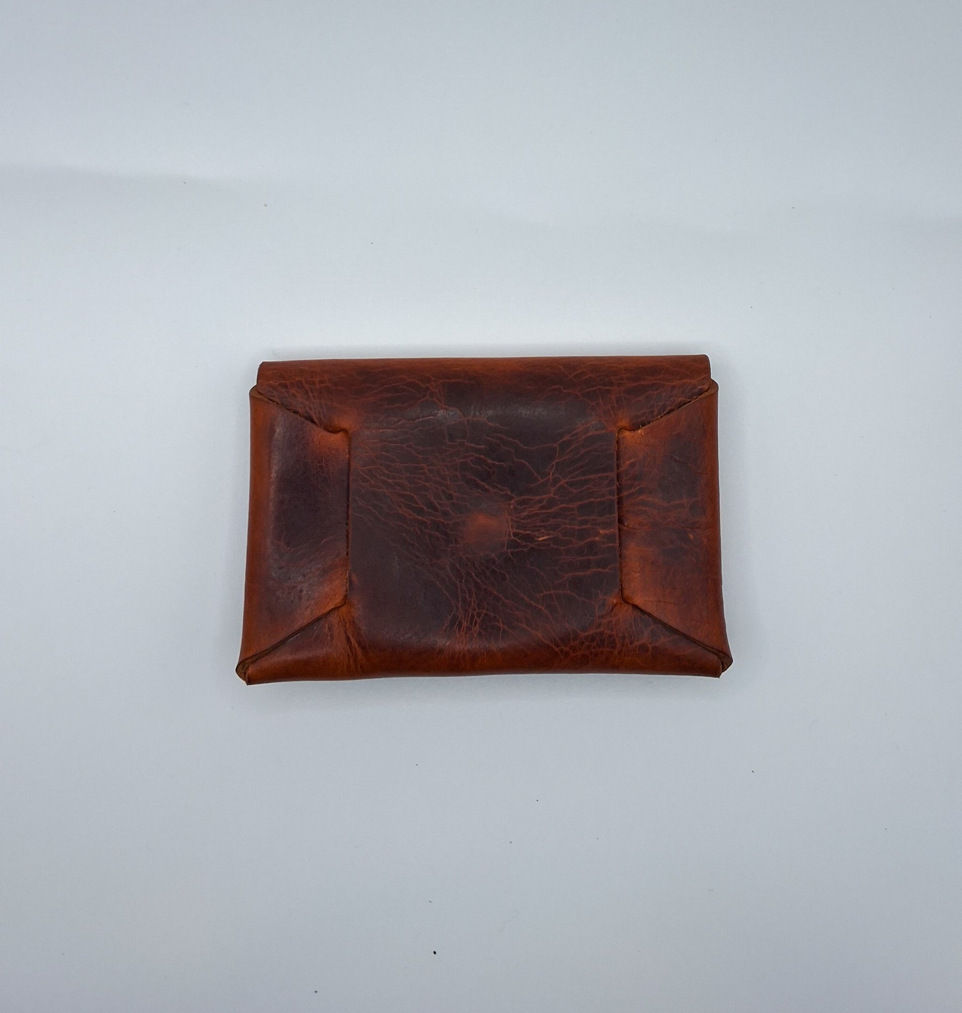 le porte carte en cuir wax marron est présenté de dos à plat sur un fond balnc