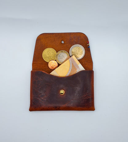 le porte carte Colette est présenté ouvert avec des pièces et un billet qui dépasse.