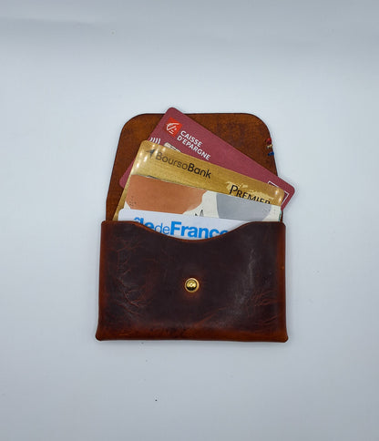 le porte carte en cuir wax marron est présenté ouvert avec des cartes qui dépassent