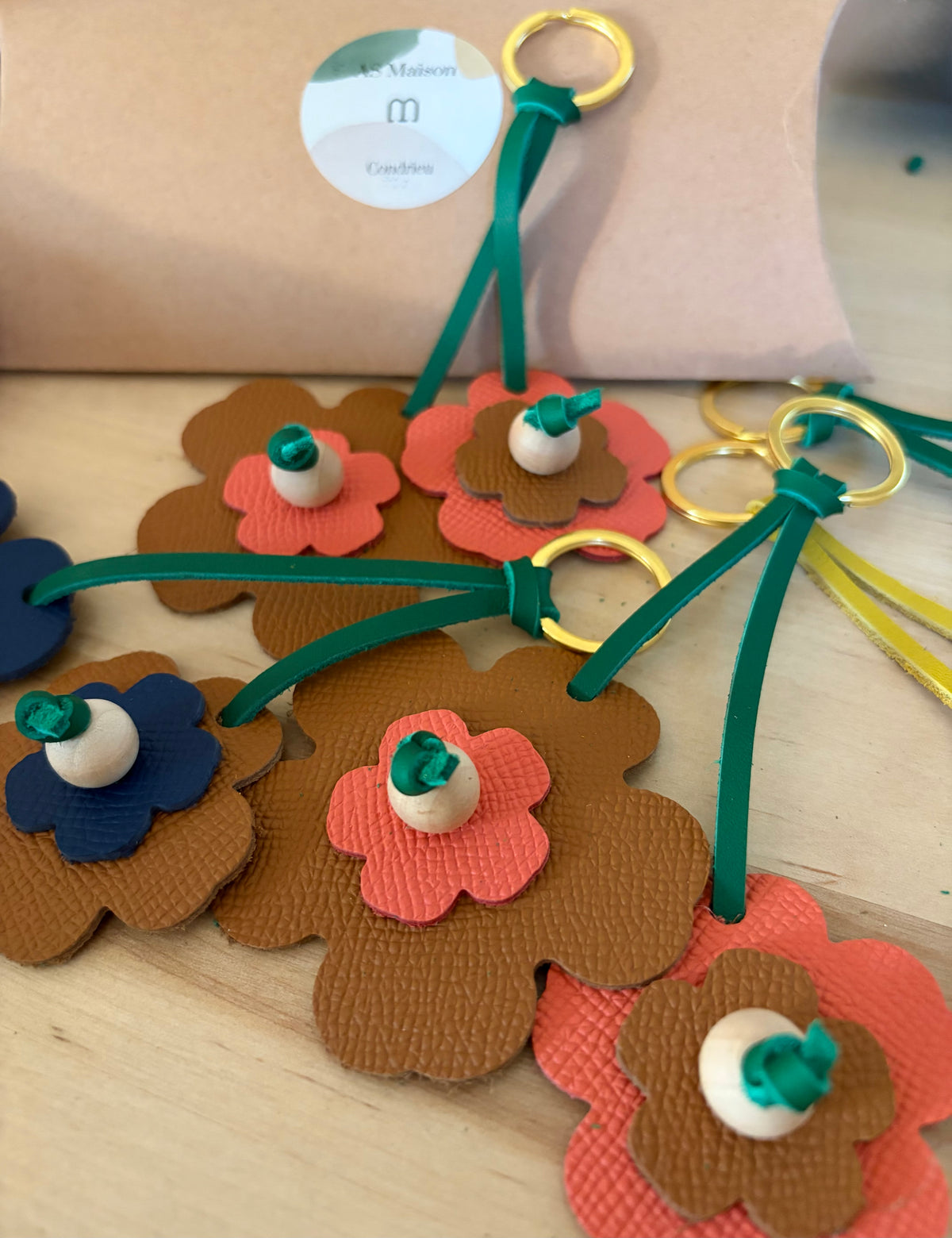 les protes clefs en cuir en forme de fleurs sont présentés ensemble sur une table en bois. 