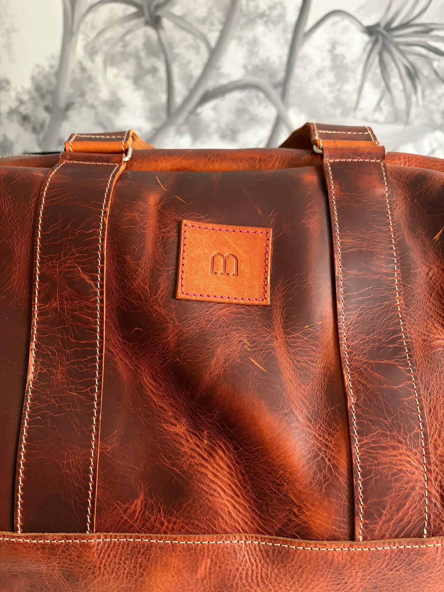 sac de voyage Marius en cuir WAX marron. Gros plan sur l'étiquette de la marque 