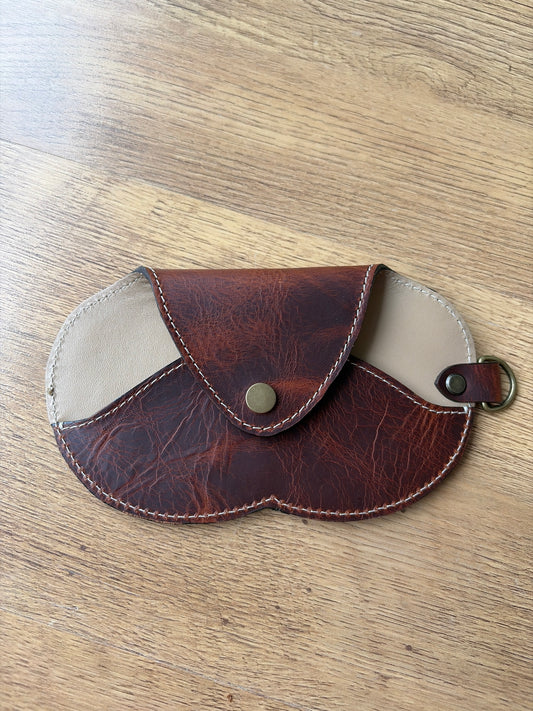 étui à lunette marron et beige sur un sol parquet bois