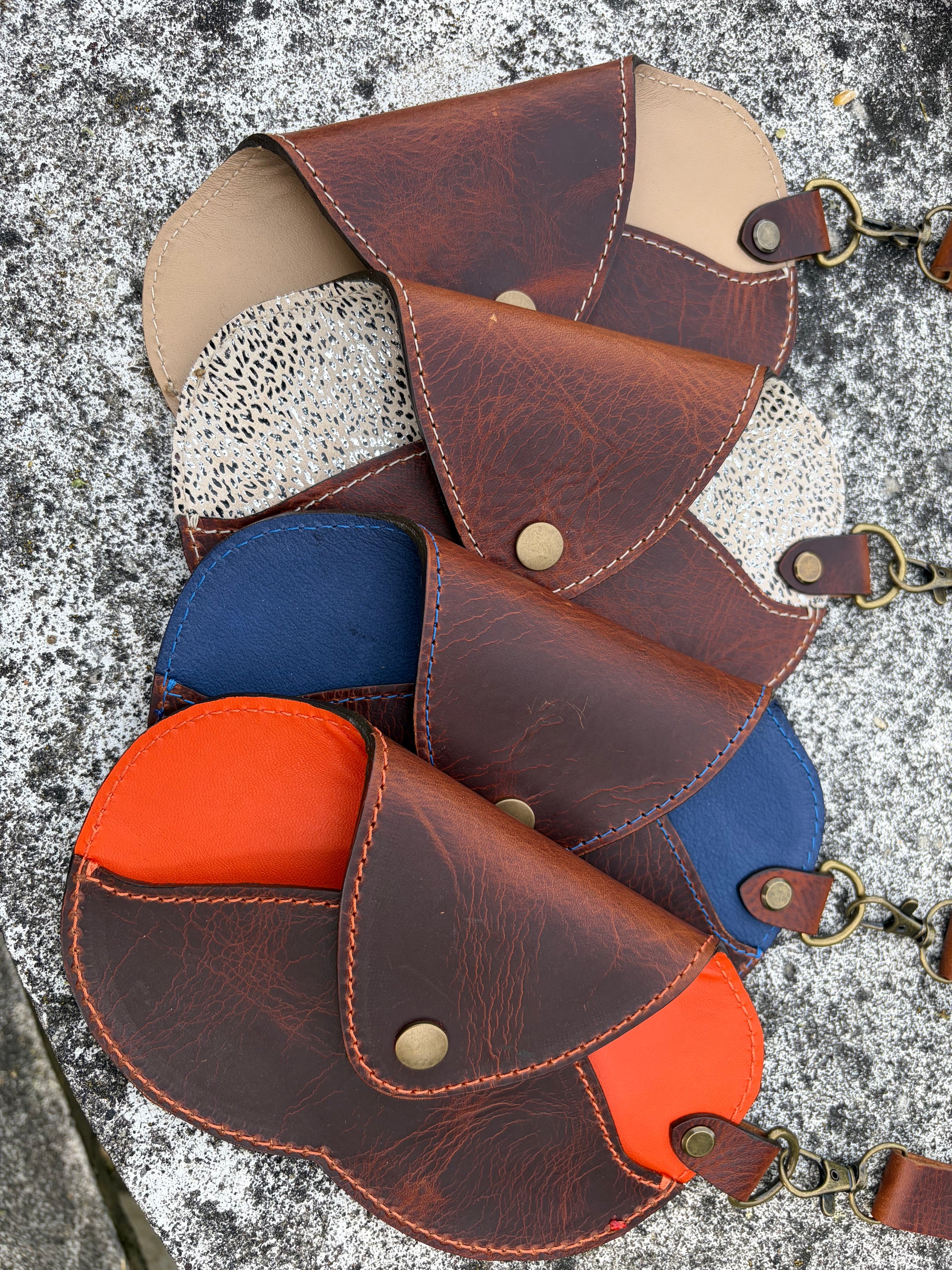 4 étuis à lunettes réalisés en cuir WAX artisanal posés sur une pierre.